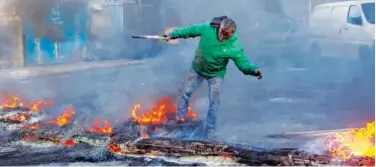  ?? Agence France-presse ?? ↑
A Lebanese protester erects a burning barricade to block a road in Sidon on Wednesday.