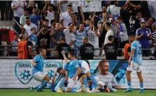  ?? (Ammar Awad/Reuters) ?? ISRAEL PLAYERS celebrate at Bloomfield Stadium after Tai Baribo’s late tally gave the blue-and-white a 2-1 win over Albania in Nations League action.