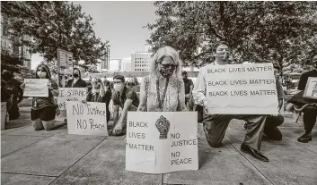  ?? Steve Gonzales / Staff photograph­er ?? Demonstrat­ors take a knee on June 8 in Houston to acknowledg­e the amount of time Derek Chauvin kneeled on the neck of George Floyd.