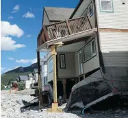  ?? Calgary Herald/files ?? A number of homes wound up heavily damaged when Cougar Creek turned into a raging river in Canmore, ripping away backyards and damaging foundation­s.