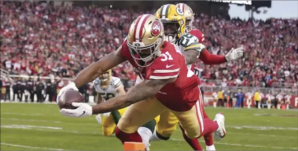  ?? AP PHOTO/TONY AVELAR ?? San Francisco 49ers running back Raheem Mostert (31) scores in front of Green Bay Packers free safety Darnell Savage during the first half of the NFL NFC Championsh­ip football game on Sunday, in Santa Clara.