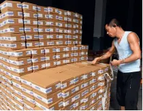  ?? ?? A worker puts labels on tea packages in the warehouse of Luyunfeng, a tea company, in Songyang County, Lishui City, Zhejiang Province