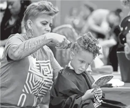  ?? ?? In this 2019 photo, Abel Blackwell gets a haircut from Jill Macon during the 2019 Love OKC One Day event inside the Oklahoma Expo Hall at State Fair Park in Oklahoma City. The 2021 event on Saturday, Oct. 2, will be a drive-thru effort due to the ongoing COVID-19 pandemic.
