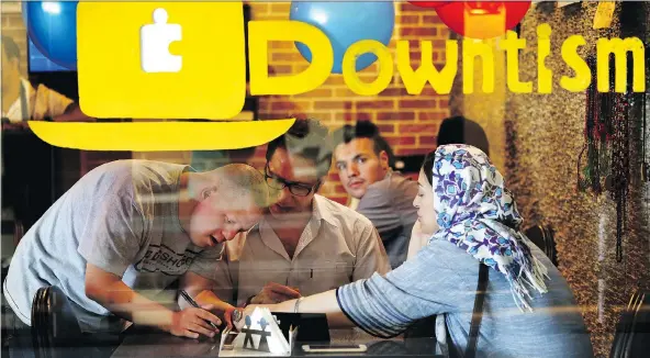  ?? PHOTOS: EBRAHIM NOROOZI/THE ASSOCIATED PRESS ?? Café staff member Ali Bakhti, left, who has Down syndrome, takes an order in Downtism Cafe in Tehran. The popular café in the city’s Vanak Square opened only three months ago, but has been constantly bustling with customers.