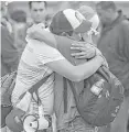  ?? David McNew / Getty Images ?? Caravan members hug as they walk across the border to ask U.S. authoritie­s for asylum.