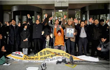  ?? — Reuters ?? Victory: Kim Seong-ju, a victim of wartime forced labour during the Japanese colonial period, cheering with her supporters and relatives of other victims after hearing the court ruling at the Supreme Court in Seoul.