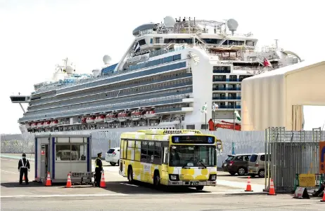  ?? — AFP photos ?? A bus carrying passengers who disembarke­d from the Diamond Princess cruise ship (back) leaves the Daikoku Pier Cruise Terminal in Yokohama.