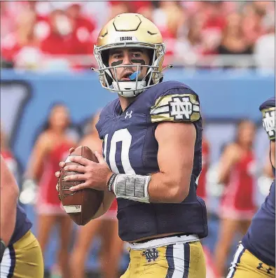  ?? Jonathan Daniel / Getty Images ?? Notre Dame QB Drew Pyne, a New Canaan alum, for a receiver against Wisconsin at Soldier Field on Saturday in Chicago.