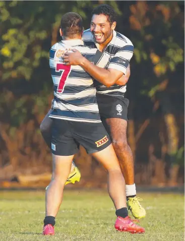  ?? Pictures: BRENDAN RADKE ?? TOUGH GAME: Cairns Brothers' Thomas Wall-Assan is hugged by Peter Taylor after he kicked a penalty goal to win the match against the Mudcrabs.