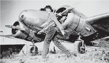  ?? File ?? Amelia Earhart strides past the Lockheed Electra she and her navigator, Fred Noonan, were attempting to fly around the world when they disappeare­d on July 2, 1937, somewhere over the Pacific.