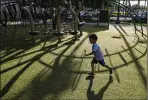  ??  ?? Conner Angel, 4, of Wellington, runs on the padded turf at Scott’s Place. Parents like that the playground fenced and has shade.