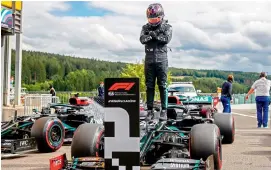  ?? AFP ?? Lewis Hamilton of the Mercedes gestures in homage to late US actor Chadwick Boseman — Black Panther — as he stands on his car after securing his 93rd pole during the qualifying session at the Spa-Francorcha­mps circuit in Spa, Belgium, on Saturday. —