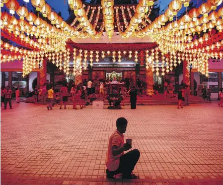  ?? JOSHUA PAUL/AP FILES ?? A tourist takes a selfie under illuminate­d traditiona­l Chinese lanterns on the eve of Lunar New Year in Kuala Lumpur, Malaysia in February 2016. Muslims are becoming key economic drivers in tourism.