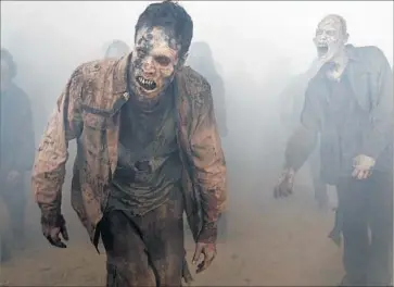  ?? Photograph­s by Gene Page AMC ?? WALKERS AREN’T the only deadly tormentors Rick’s group faces in a new season of “The Walking Dead.”
