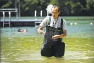  ??  ?? Edwin Wong, a biology professor at Western Connecticu­t State University, takes a sample of water from the beach at Lynn Demning Park in New Milford on July 21, 2016. That sample was to be tested for toxins.