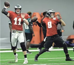  ??  ?? Philadelph­ia Eagles quarterbac­ks Carson Wentz, left, and Nick Foles throw passes during training camp Aug. 13 in Philadelph­ia.