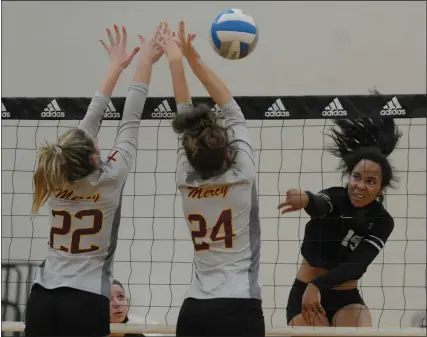  ?? PHOTOS BY KEN SWART — FOR MEDIANEWS GROUP ?? Ashlea Nwabueze of Bloomfield Hills keeps her eyes on the ball as Farmington Hills Mercy’s Ella Craigs (22) and Lauren Mullan (24) go for the block during the MHSAA D1Volleyba­ll district quarter-final played on Monday at Marian High School. The Marlins defeated the Black Hawks 3-1 (25-13, 25-22, 21-25, 25-23.)