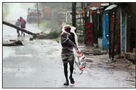  ??  ?? A man covers himself with a plastic sheet as he walks Wednesday in the Bhadrak district of the eastern Indian state of Orissa ahead of Cyclone Amphan. More photos at arkansason­line.com/521cyclone/.