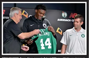  ?? CHRIS CHRISTO / BOSTON HERALD ?? FIRST ROUNDER: Danny Ainge presents Robert Williams with his new jersey as coach Brad Stevens looks on during Williams’ introducti­on to the team at the Auerbach Center.