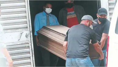  ?? FOTO: ESTALIN IRÍAS ?? Familiares retiran el cuerpo de Juan Alfonso Molina Ortiz, quien fue asesinado en Juticalpa, Olancho.