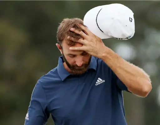  ?? Kevin C. Cox/Getty Images ?? Dustin Johnson reacts on the 18th green in the second round of the Masters Friday at Augusta National Golf Club. He made bogey on three of his final four holes.