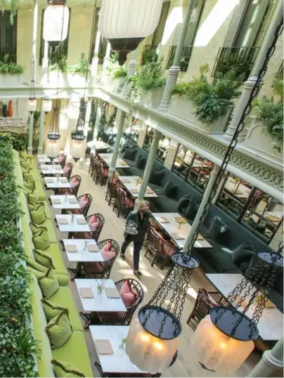  ??  ?? Set inside a lushly landscaped atrium with a soaring glass ceiling, the space is flooded with natural light providing energy and liveliness during the day. In the evening, the restaurant transforms to a more intimate setting, revealing its moody and sensual character.