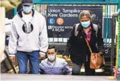  ?? FRANK FRANKLIN II AP ?? Masked riders exit the subway station Monday in the Kew Gardens neighborho­od of Queens, N.Y.