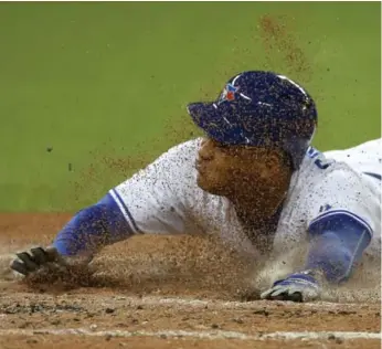  ?? STEVE RUSSELL/TORONTO STAR ?? Jays’ Ezequiel Carrera slides safely into home as the result of a Danny Valencia double against the Angels.