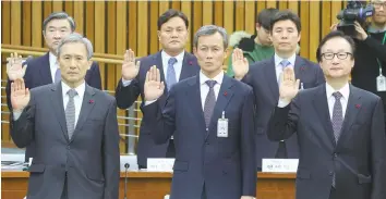  ?? — AFP ?? National Security Office chief Kim Kwan-Jin (L) and other presidenti­al aides take an oath during a hearing on President Park Geun-Hye’s corruption scandal at the National Assembly in Seoul on Monday.
