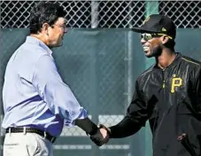  ?? Peter Diana/Post-Gazette ?? Owner Bob Nutting greets outfielder Andrew McCutchen, the subject of constant trade rumors in the offseason, before workouts Monday at Pirate City in Brandenton, Fla.