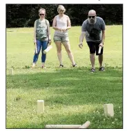  ?? Arkansas Democrat-Gazette/SEAN CLANCY ?? Sasha O’Quin (from left) and Ramona Hicks watch as Kyle Hicks tosses a baton at wooden blocks called kubbs during a game of Kubb at Burns Park in North Little Rock.