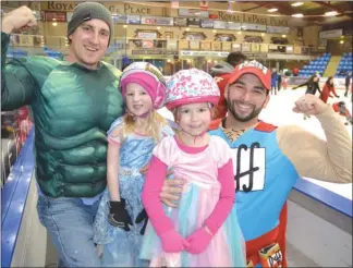  ?? RON SEYMOUR/The Daily Courier ?? Brady Loseth, dressed as the Hulk, left, holds his daughter Ayla while Chris Helbig, as Duff Man, poses with his daughter Isabel on Sunday at Royal LePage Place arena in West Kelowna. They were among dozens of people participat­ing in a costume-themed...