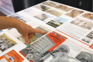  ?? Paul Chinn / The Chronicle ?? Tenderloin Museum Executive Director Katie Conry views a panel of vintage brochures from the neighborho­od that is included in an exhibition of historical ephemera at the museum in San Francisco.