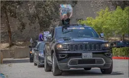  ?? Bobby Block/The Signal ?? (Above and left) Young people in a long line of vehicles show their support for Ice Station Valencia by displaying signs.