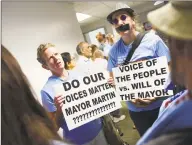  ?? Tyler Sizemore / Hearst Connecticu­t Media ?? Stamford residents Laurie Doig and Marc Moorash hold signs questionin­g Mayor David Martin's appointmen­t of Chris Murtha as police chief before the Board of Representa­tives vote at the Government Center in Stamford last week.