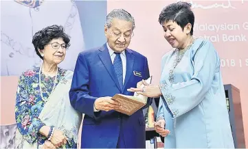  ?? — Bernama photo ?? Tun Mahathir (middle) and Dr Siti Hasmah (left) are being briefed by Nor Shamsiah about the launch of the “Tun Ismail Ali – Paragon of Trust and Integrity” memoir yesterday.