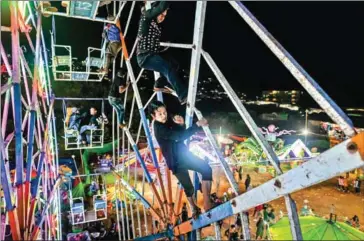  ?? CREDITYE AUNG THU/AFP ?? Aung Sein Phyo (centre) and other crew members operate a human-powered ferris wheel in Taunggyi in Myanmar’s Shan state.