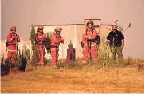  ?? NOAH BERGER/AP ?? Inmate firefighte­rs prepare to work against the River Fire in Salinas, Calif., on Aug. 17. Fire crews across the region scrambled to contain dozens of blazes sparked by lightning strikes.