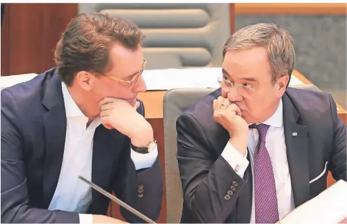  ?? FOTO: ROLAND WEIHRAUCH/DPA ?? Vor Corona ohne Maske sind Hendrik Wüst (l.) und Armin Laschet im Februar vergangene­n Jahres im Landtag in ein Gespräch vertieft.