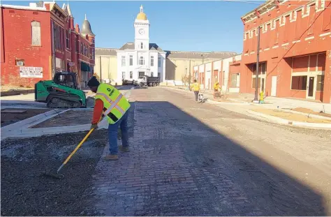  ?? (Pine Bluff Commercial/Eplunus Colvin) ?? Streetscap­e workers prepare Main Street for an asphalt overlay as phase one of Streetscap­e is projected to wrap up at the end of February. Other features of phase one include installing benches and landscape improvemen­ts.