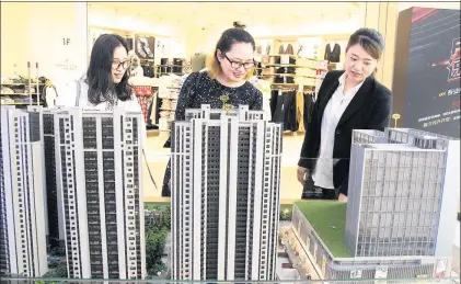  ?? WANG JIANKANG / FOR CHINA DAILY ?? A representa­tive of a real estate developer in Suzhou promotes an upcoming project to prospectiv­e buyers at a shopping mall, where a model of the property was kept on display at an industry event.