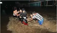  ?? ZUBAIDILLA­H/JAWA POS RADAR BROMO ?? SETINGGI LUTUT: Warga mendorong motor yang terjebak banjir.