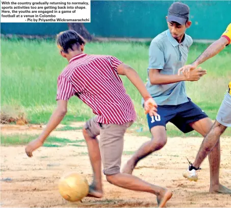  ?? - Pic by Priyantha Wickramaar­achchi ?? With the country gradually returning to normalcy, sports activities too are getting back into shape. Here, the youths are engaged in a game of football at a venue in Colombo