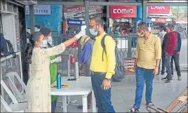  ?? DEEPAK SANSTA / HT ?? Health workers checking the body temperatur­e of passengers before they board a bus in Shimla on Thursday.