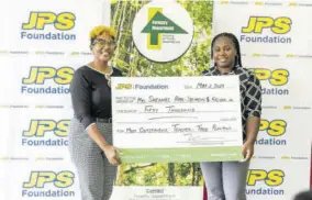  ?? ?? Most outstandin­g teacher in the Forestry Department’s National School Tree Planting Competitio­n, Shennel Haye-stephens (right), proudly accepts her cash award of $50,000 from head of JPS Foundation Sophia Lewis at the presentati­on ceremony held at York Castle High School recently.