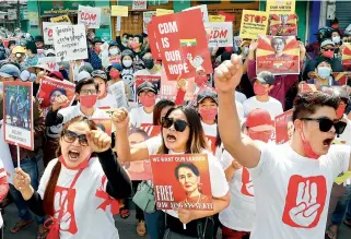  ?? — AP ?? Protesters raise their hands with clenched fists during an anti-coup rally in front of the Myanmar Economic Bank in Mandalay, Myanmar on Monday.