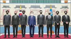  ?? AFP ?? South Korean President Moon Jae-in (fourth lefy) poses with members of K-pop sensation BTS as they receive diplomatic passports for a UN session as presidenti­al special envoys.