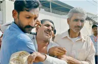  ?? — AP ?? People comfort a family member of a police officer killed during a shootout at the Chinese Consulate in Karachi on Friday.