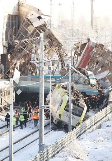  ?? — Reuters photo ?? Rescue workers search at the train crash site.