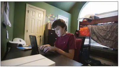  ?? (NWA Democrat-Gazette/J.T. Wampler) ?? Jordan Lantinga, 13, does school work from his home in Fayettevil­le on Dec. 16. He is attending virtual school through the Fayettevil­le School District. His mother, Andrea Lantinga, says that while the online method is “not perfect,” the district is doing a good job. More photos at arkansason­line.com/1227edpoll/.